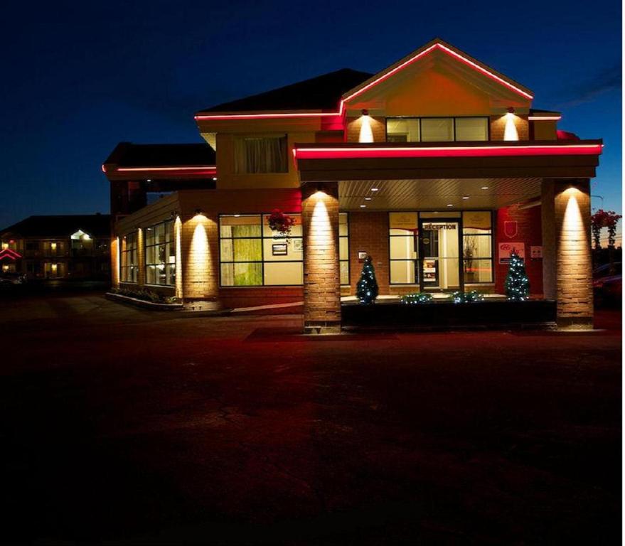 un bâtiment avec des arbres de Noël devant lui dans l'établissement Hotel-Motel Drummond, à Drummondville