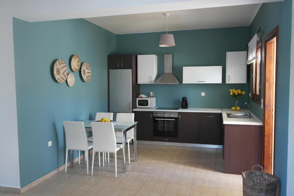 eine Küche mit blauen Wänden sowie einem Tisch und Stühlen in der Unterkunft Country Bellavista Darmarohori in Darmarochori
