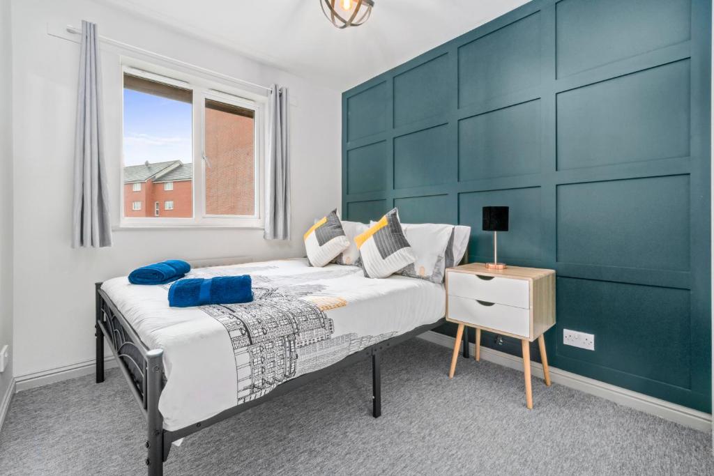 a bedroom with a large bed with a blue wall at I'm Your Host - Bridgeton House in Glasgow