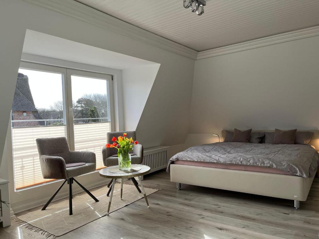 una camera con letto, tavolo e sedia di Ferienwohnung-Weidenstieg-OG a Wenningstedt