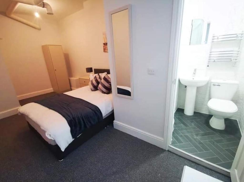 a bedroom with a bed and a sink and a toilet at Wardwick Guest House in Derby