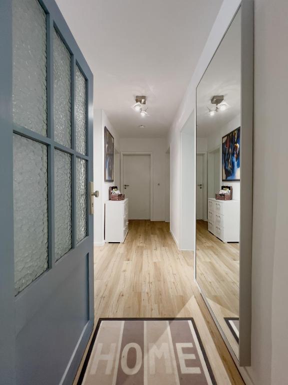 a hallway with white walls and a glass door at Schöne helle & gemütliche Wohnung in Altstadtnähe in Erfurt