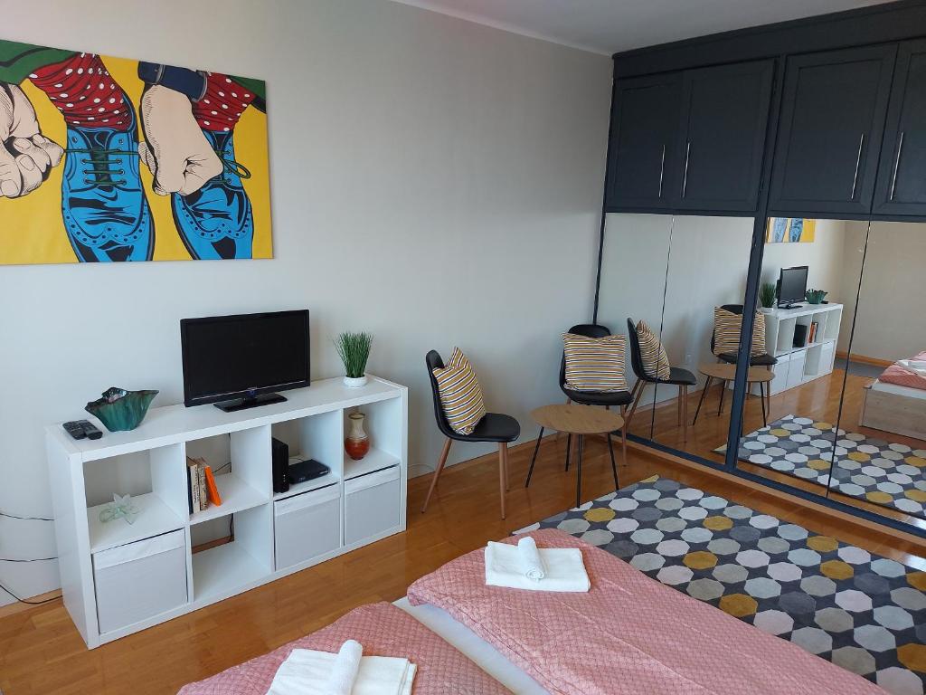 sala de estar con 2 camas y TV de pantalla plana en Olaszrizling Apartman en Veszprém