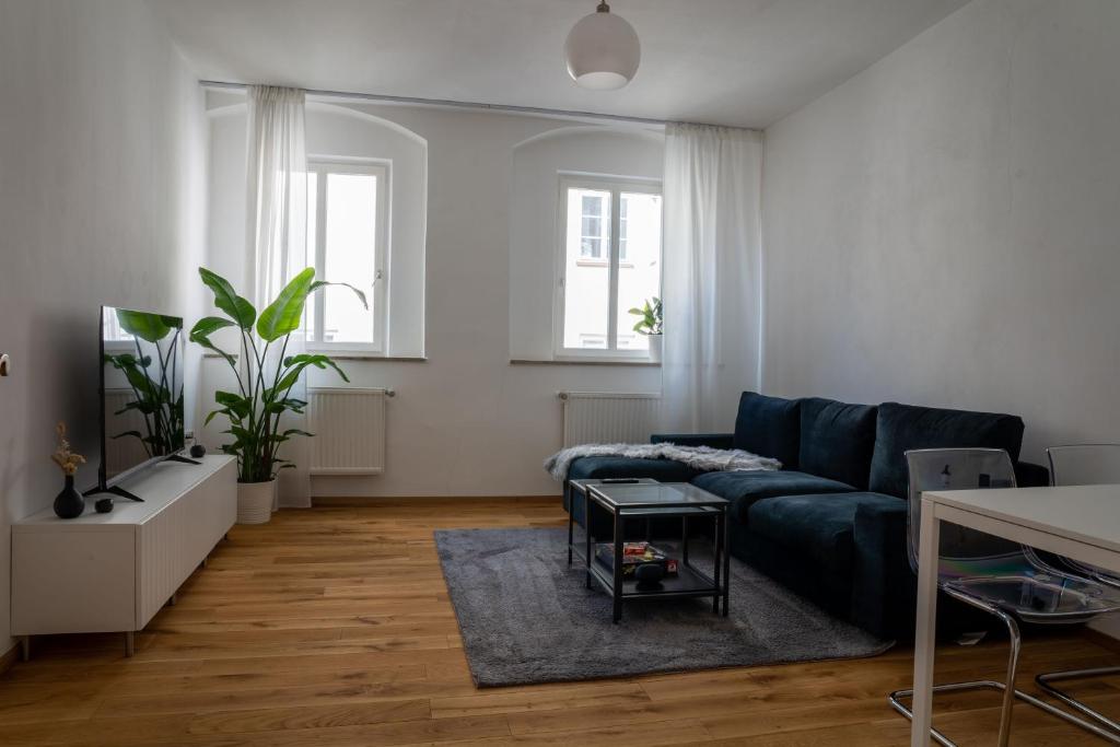 ein Wohnzimmer mit einem blauen Sofa und einem Tisch in der Unterkunft Altstadtjuwel Liboria in Augsburg