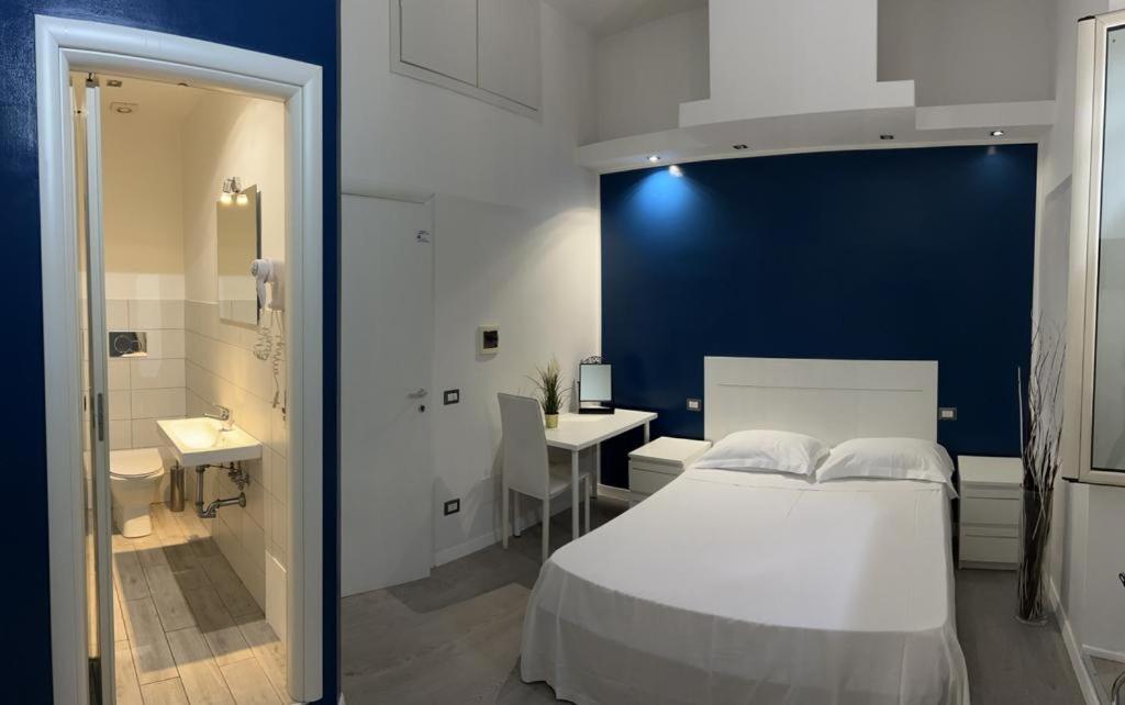 a bedroom with a white bed and a bathroom at Boutique Rooms in Rome