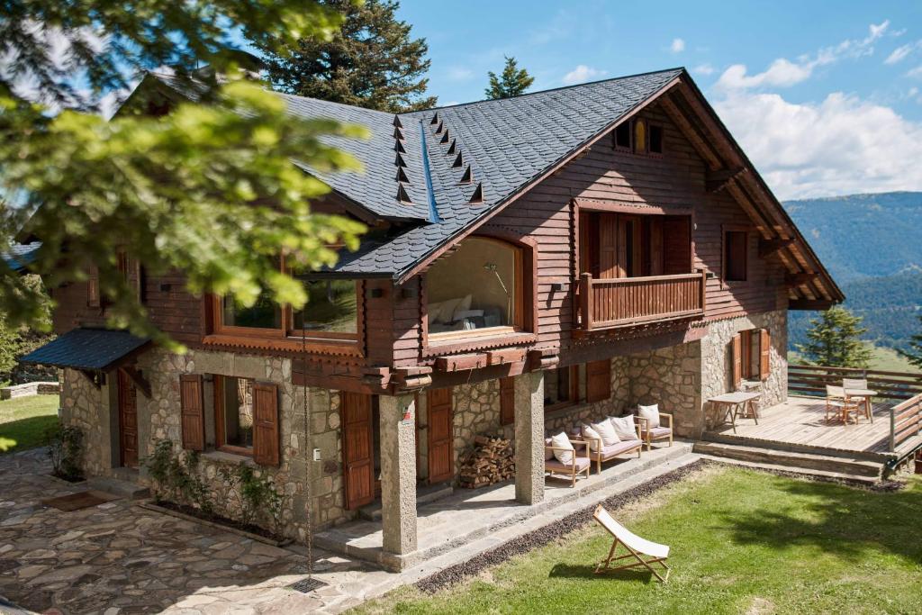 a wooden house with a porch and a balcony at Casa Pyrenees - Slow Life Refuge in La Molina