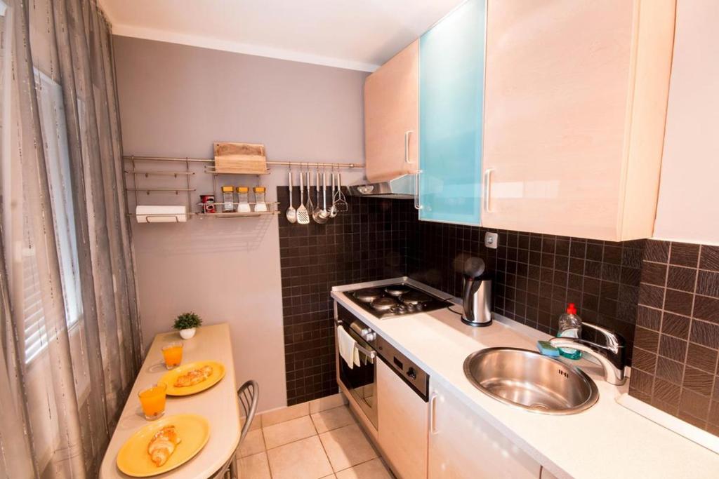 a small kitchen with a sink and a stove at Apartmani Barnjak in Zagreb