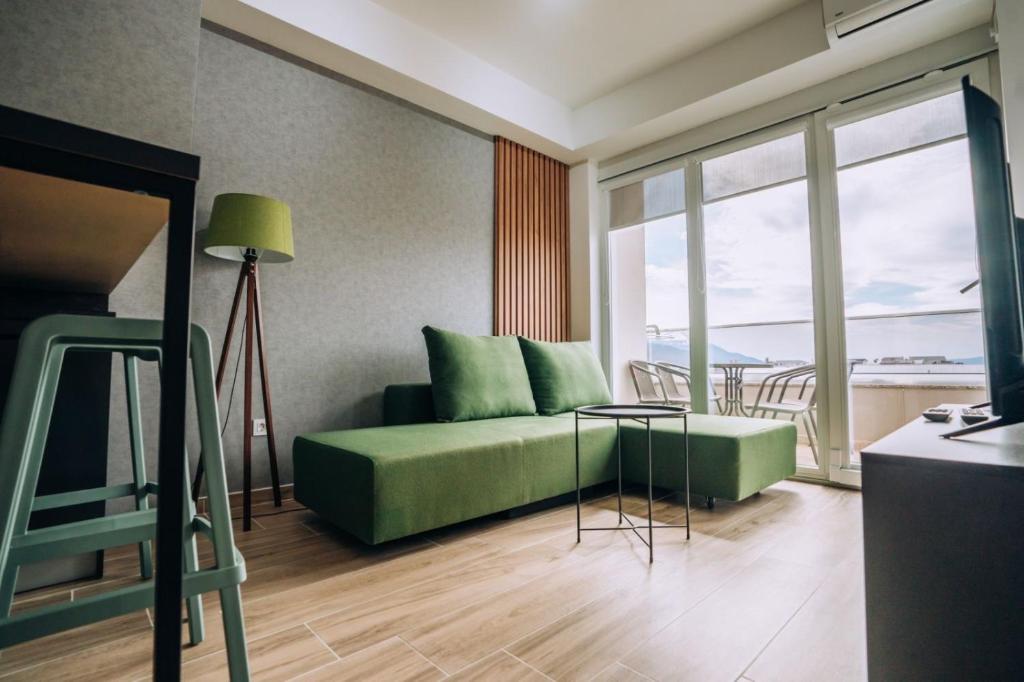 ein Wohnzimmer mit einem grünen Sofa und einem Tisch in der Unterkunft Leon Luxury Apartments in Ohrid