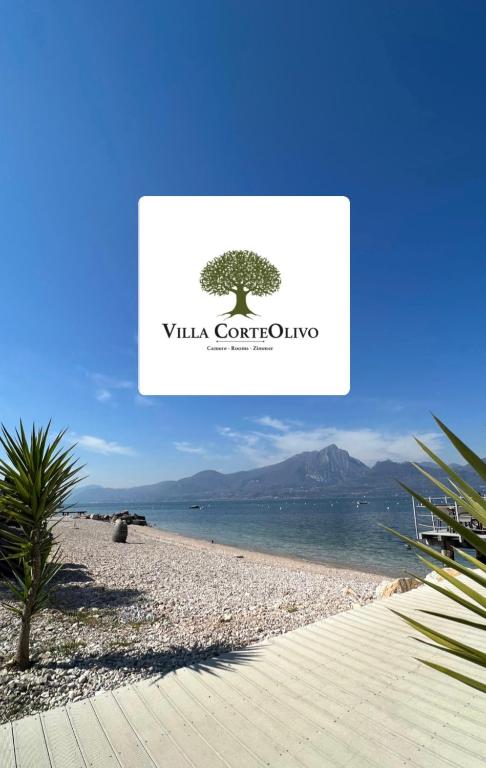 a sign on a beach with a tree on it at Villa CorteOlivo Rooms in Torri del Benaco