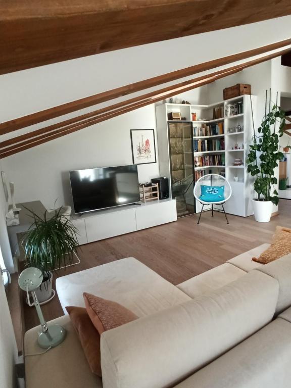 a living room with a white couch and a tv at Appartamento Vero_Arco in Arco