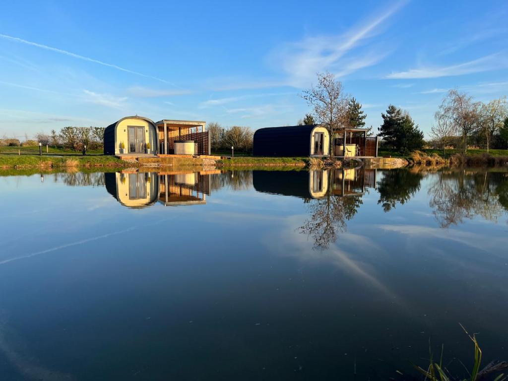 um grupo de pequenas estruturas sentadas no topo de um lago em New Farm Cheshire Holidays em Winsford