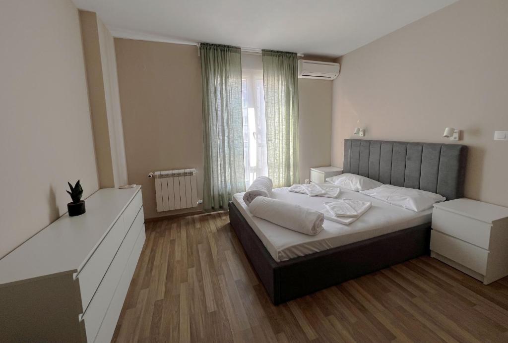 a bedroom with a bed and a large window at Lubata 5 Apartments - 2 bedrooms in Sofia