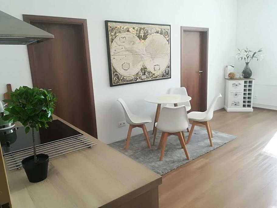 a living room with a table and white chairs at Diamond residence in old town in Bratislava