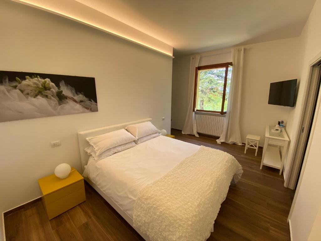 um quarto com uma cama branca e uma janela em Villa Rina em Pesaro