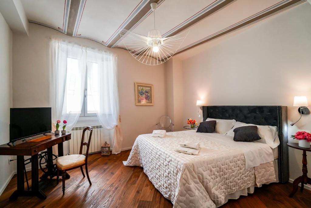 a bedroom with a large bed and a desk at Maison Portica 29 in Assisi