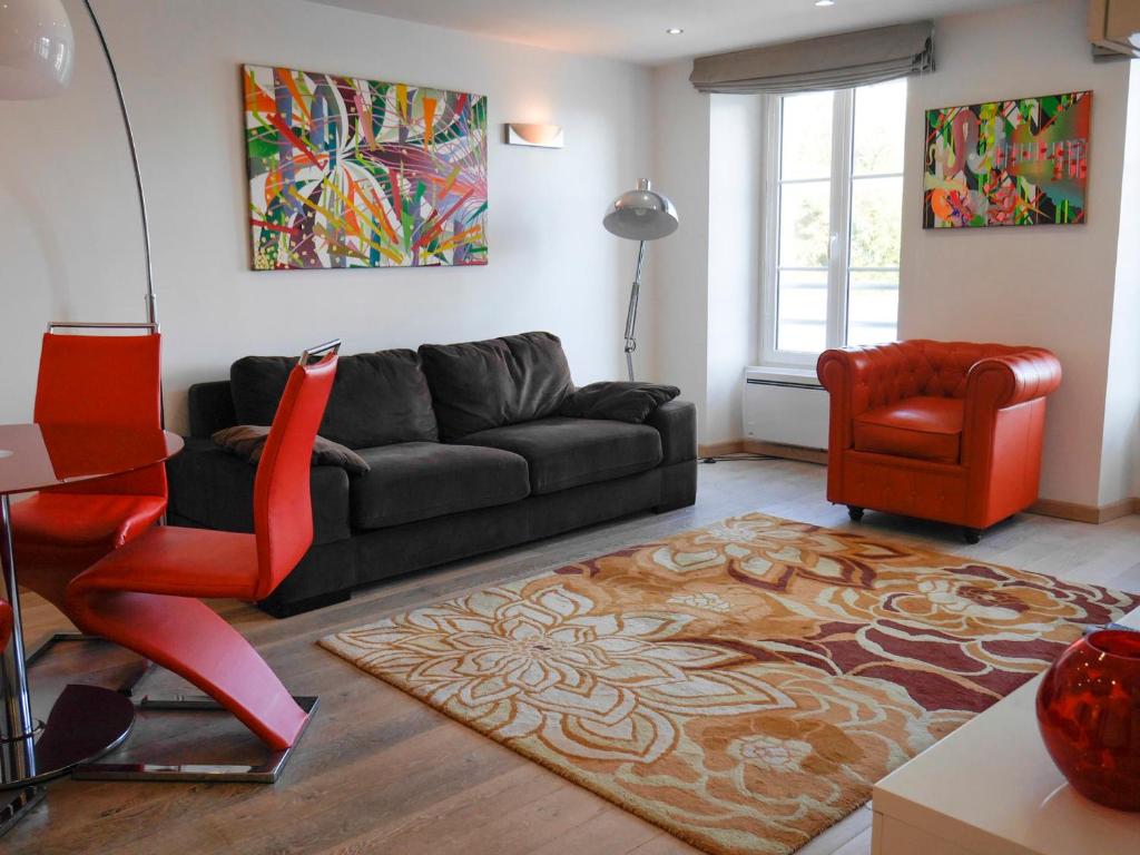 uma sala de estar com um sofá preto e uma cadeira vermelha em Appartement Le Palais, 2 pièces, 6 personnes - FR-1-418-177 em Le Palais