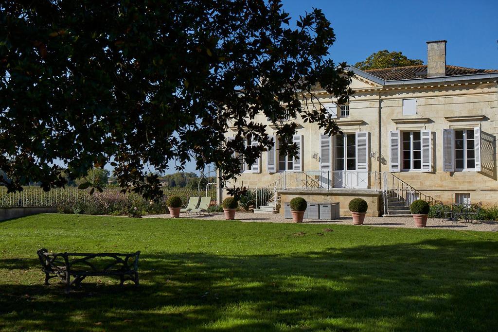利布爾訥的住宿－葡萄園里美麗迷人的豪華度假屋，大型建筑前的公园长凳