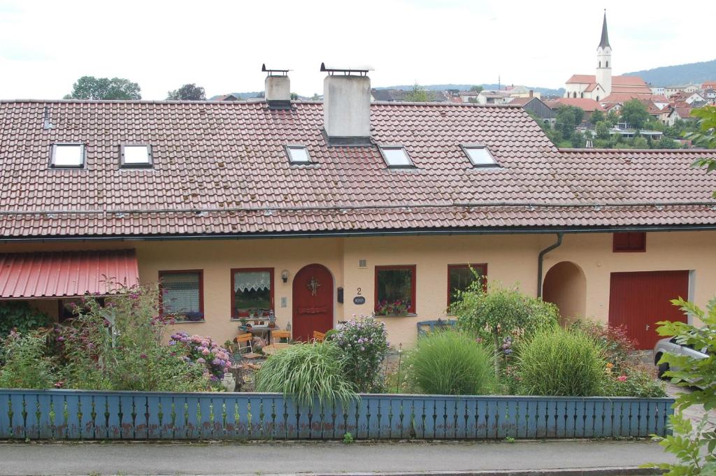 a house with a red roof with a garden at Freyung, Ferienwohnung Sonnenschein in Schönberg