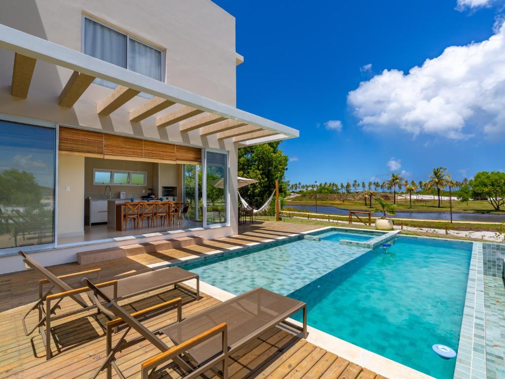 a villa with a swimming pool and a deck at Reserva Sauípe - Casa 189 in Costa do Sauipe