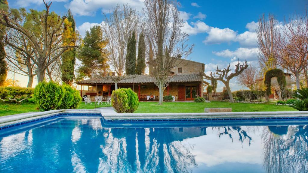 uma casa com piscina em frente a uma casa em Casa Rural Lo molí em Juneda