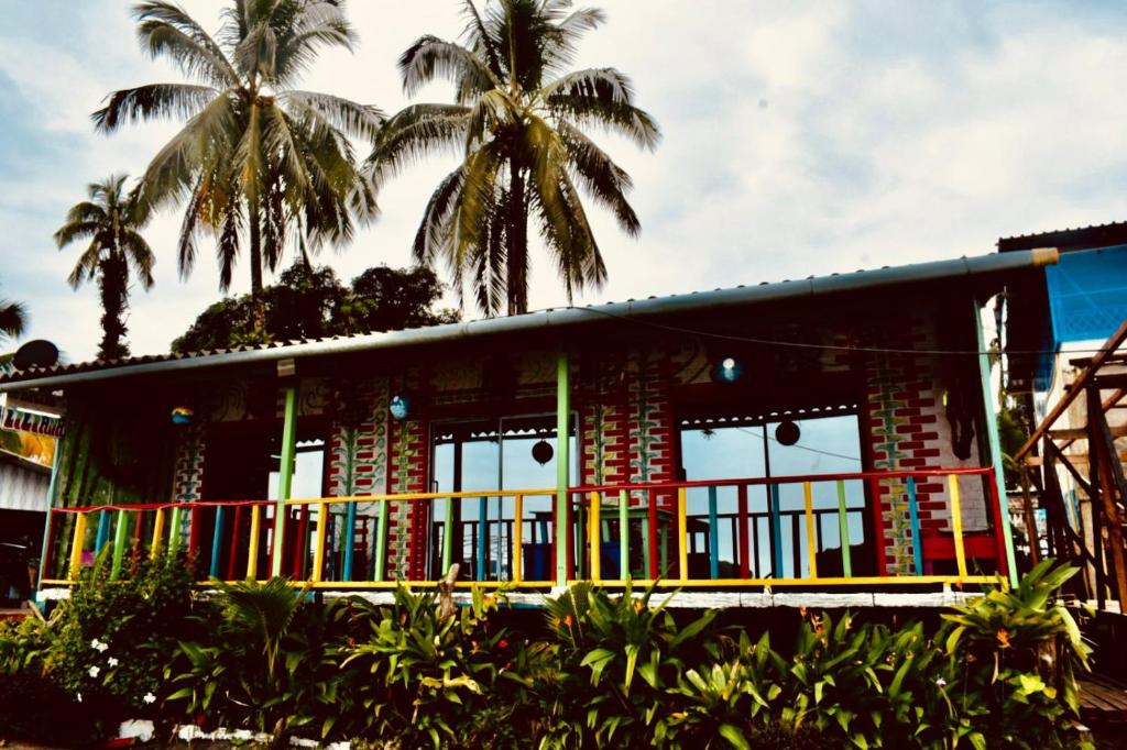 a colorful house with palm trees in front of it at Hostal Liliana in Buenaventura