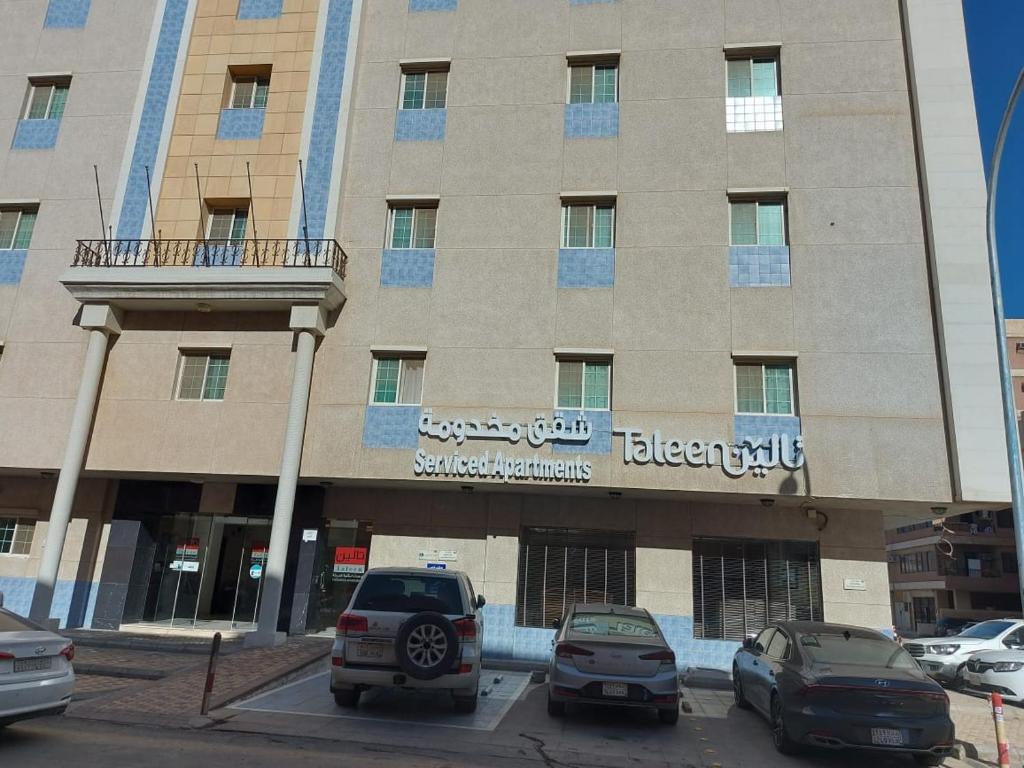 a large building with cars parked in a parking lot at تالين الجامعي in Riyadh