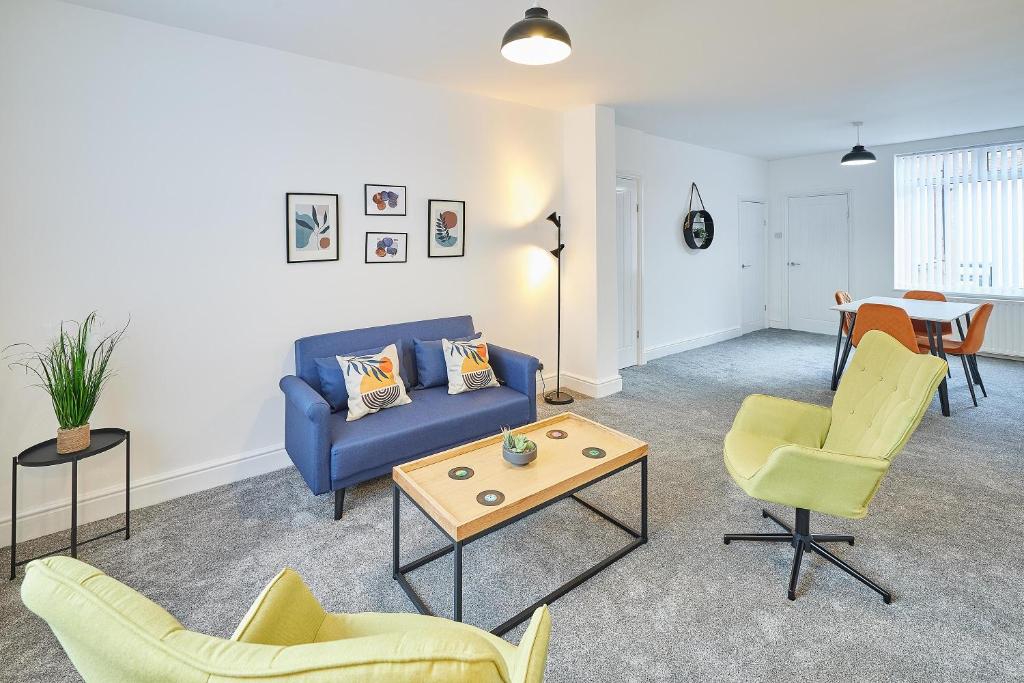 a living room with a blue couch and chairs at Host & Stay - North Seaton Road in Newbiggin-by-the-Sea