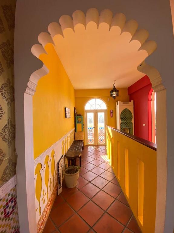 a hallway in a house with a yellow and red wall at Raid Garden Boutique Hotel in Magong