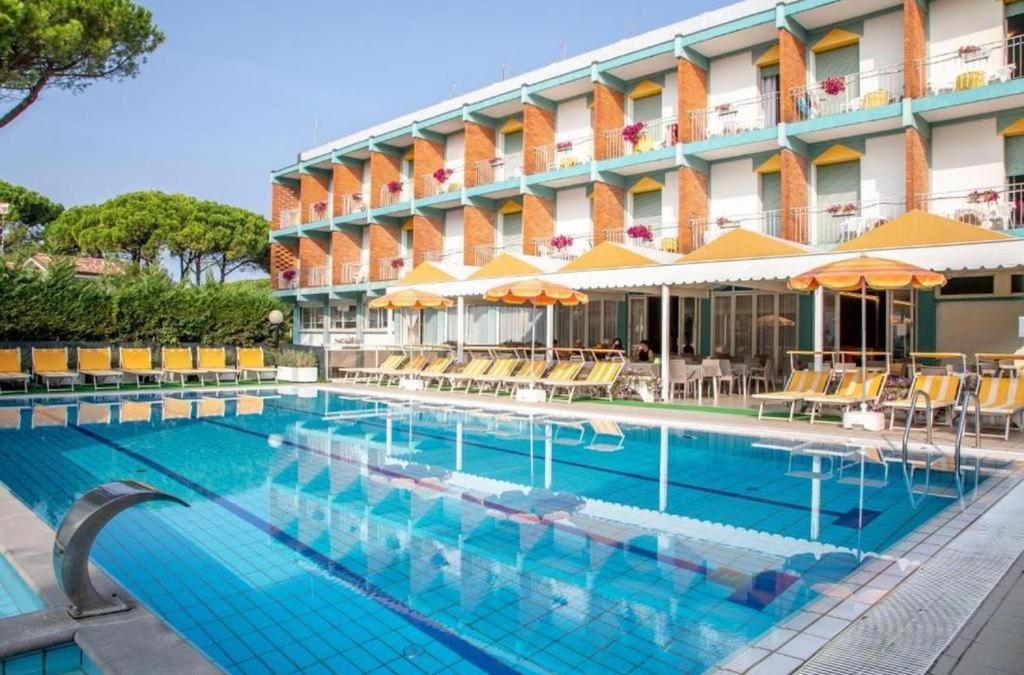 a swimming pool in front of a hotel at Hotel Palm Beach in Lido di Jesolo