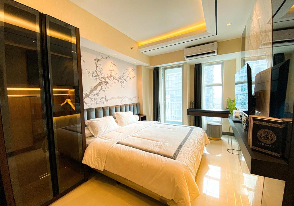 Schlafzimmer mit einem Bett und einem Flachbild-TV in der Unterkunft Luxury Modern La Casa II Benson in Lontar