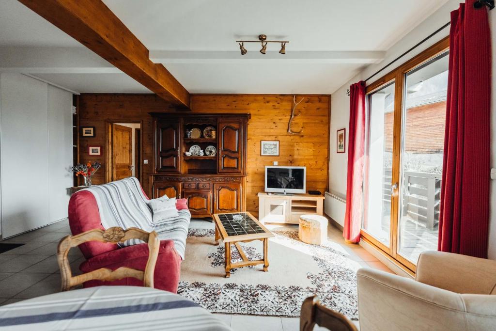 ein Wohnzimmer mit einem Sofa und einem TV in der Unterkunft Spacious apartment with garage and balcony overlooking the mountains in Saint-Gervais-les-Bains