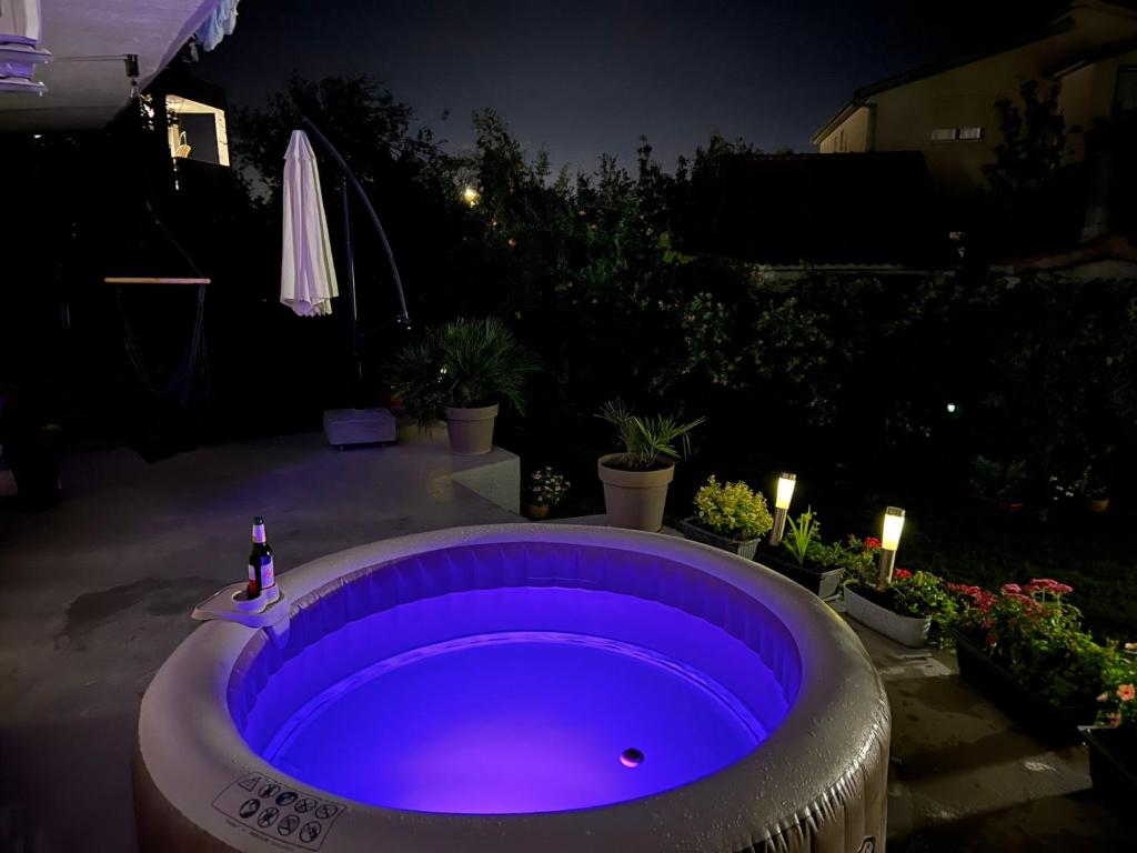 - un bain à remous violet dans l'arrière-cour la nuit dans l'établissement Apartmani Dolores, à Kaštela
