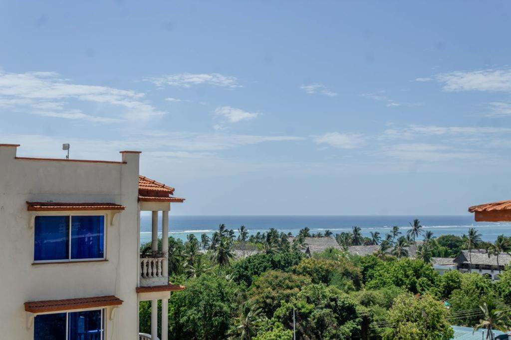 un edificio con vistas al océano en el fondo en Ikhaya serviced Apartments With Sea View, Nyali, en Mombasa