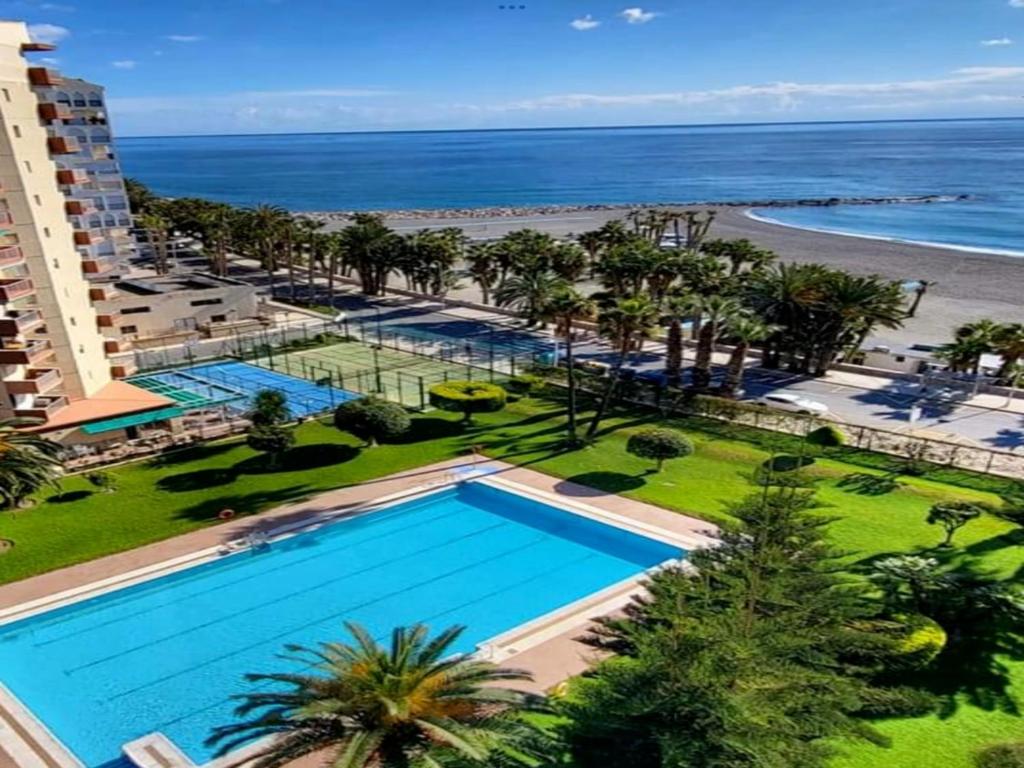 een uitzicht over het zwembad en het strand bij Apartamento Las Góndolas Playa ALOJAMIENTOS VISTAMAR in Almuñécar