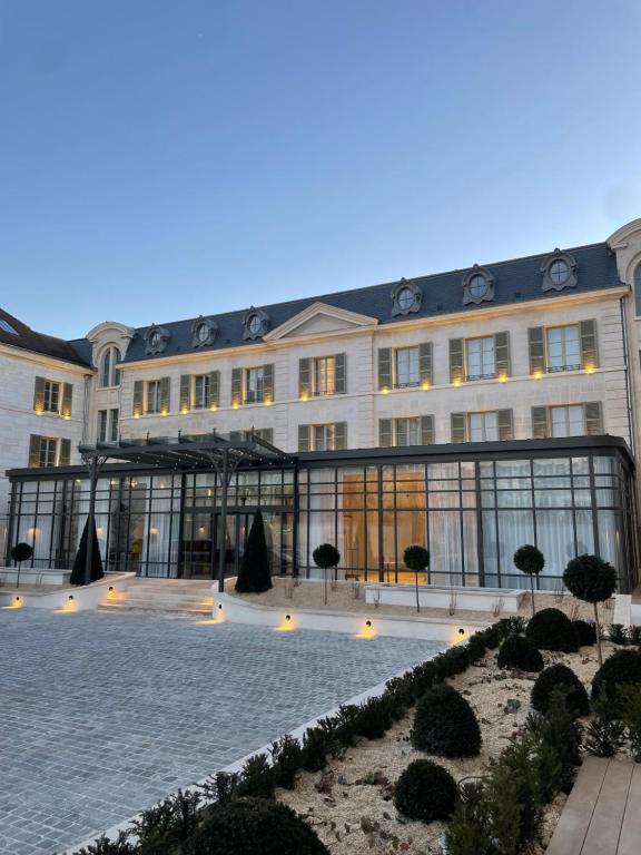 トロワにあるLa Licorne Hotel & Spa Troyes MGalleryの中庭が目の前にある大きな建物