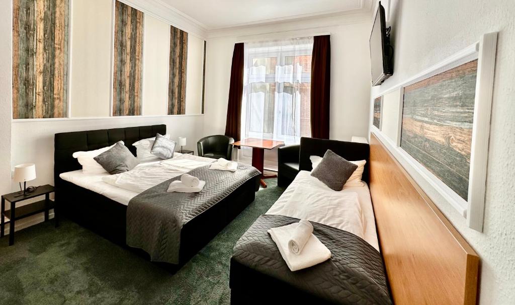Habitación de hotel con 2 camas y sofá en Hotel Nord, en Hamburgo