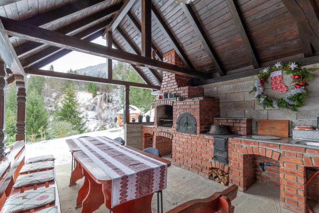 VidraにあるCasa de Vacanta Cascadaの屋外パティオ(レンガ造りのオーブン、テーブル付)