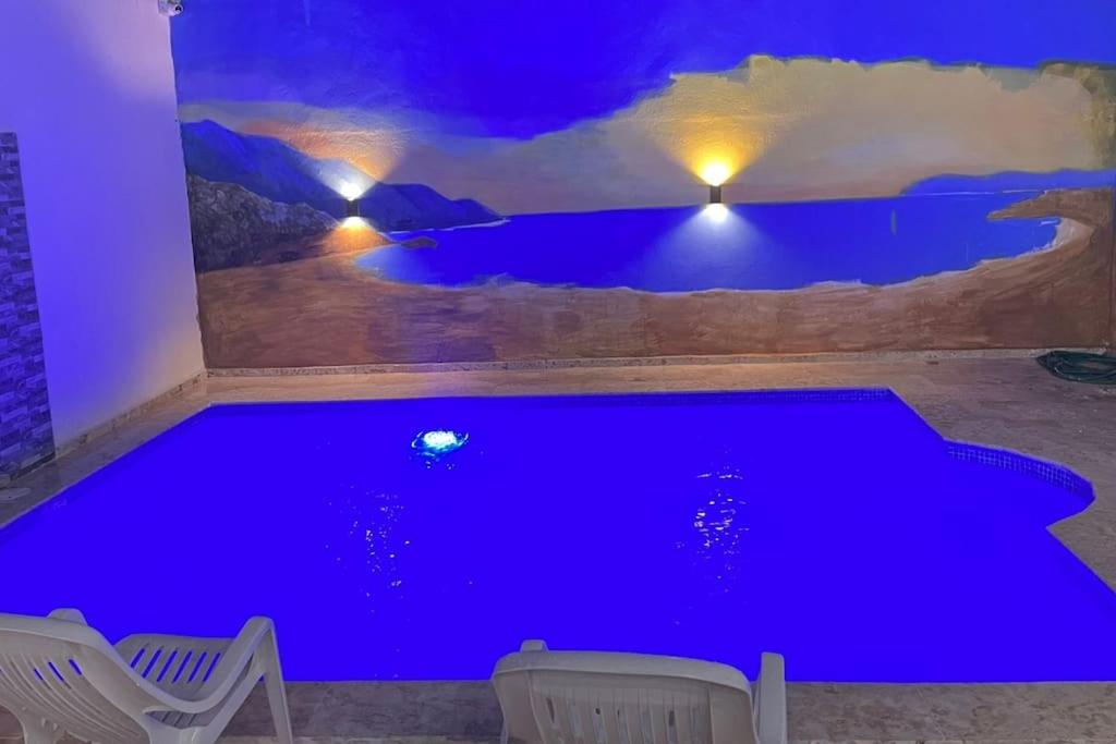 a large blue pool in a room with chairs at Complejo Giraflor in Pantoja