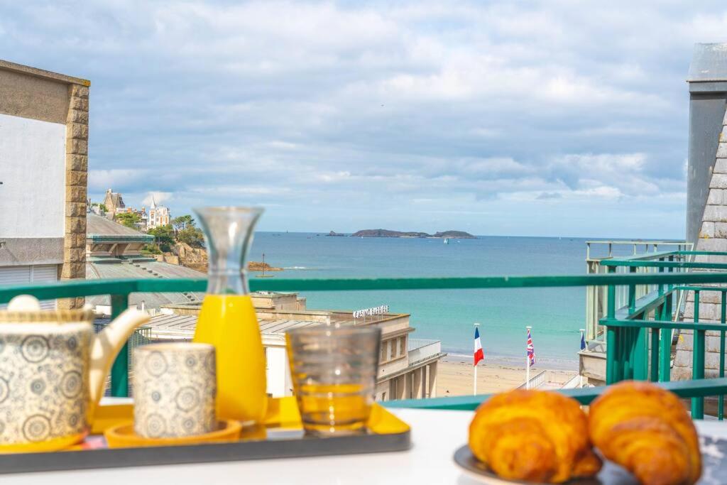 uma mesa com uma bandeja de comida e vista para a praia em Studio vue mer en Centre-Ville em Dinard