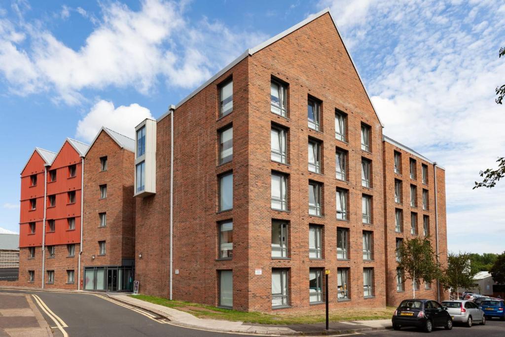 un grand bâtiment en briques rouges dans une rue dans l'établissement For Student Only Classic Studio at The Glassworks near Newcastle City Centre, à Newcastle upon Tyne