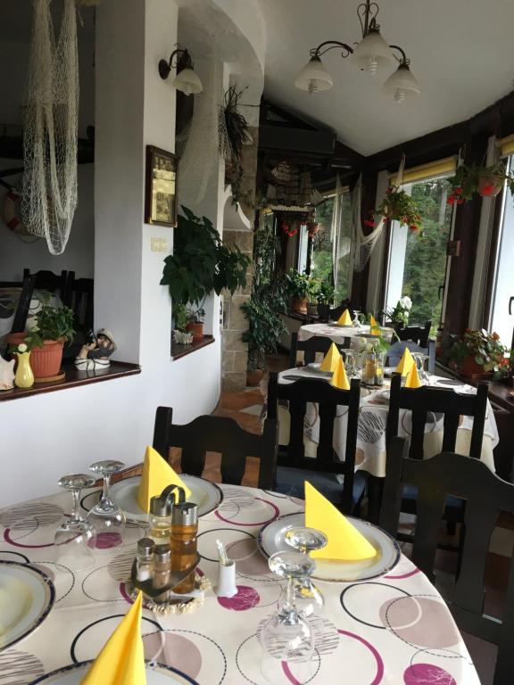 una sala da pranzo con tavoli e sedie con tovaglioli gialli di Ancora a Predeal