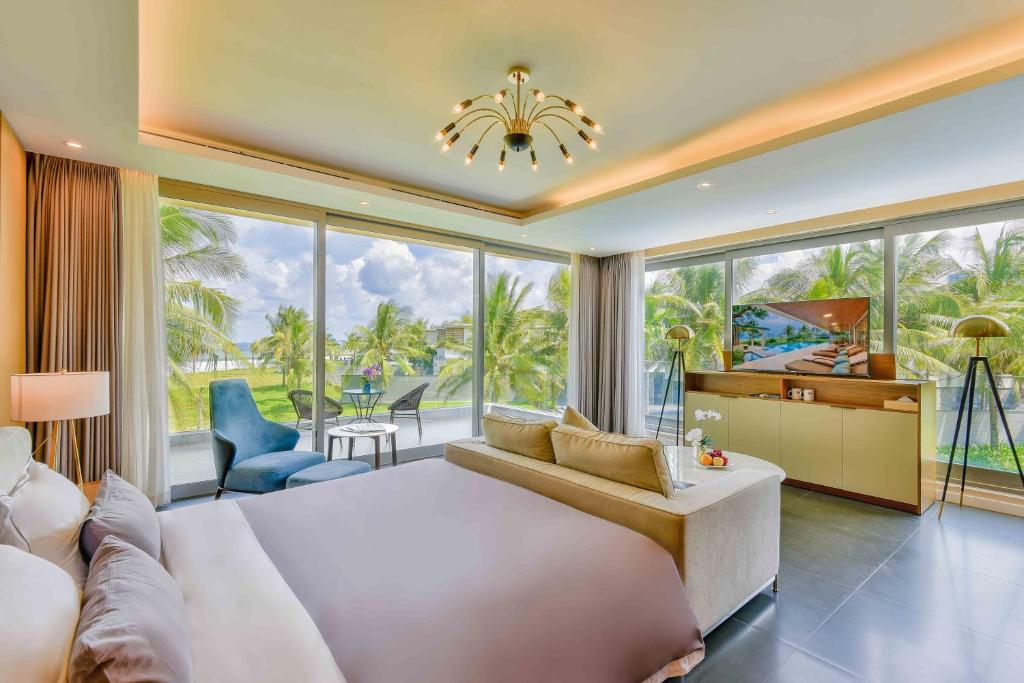 a bedroom with a large bed and a large window at Deluxe Beach Villas by Danatrip in Danang