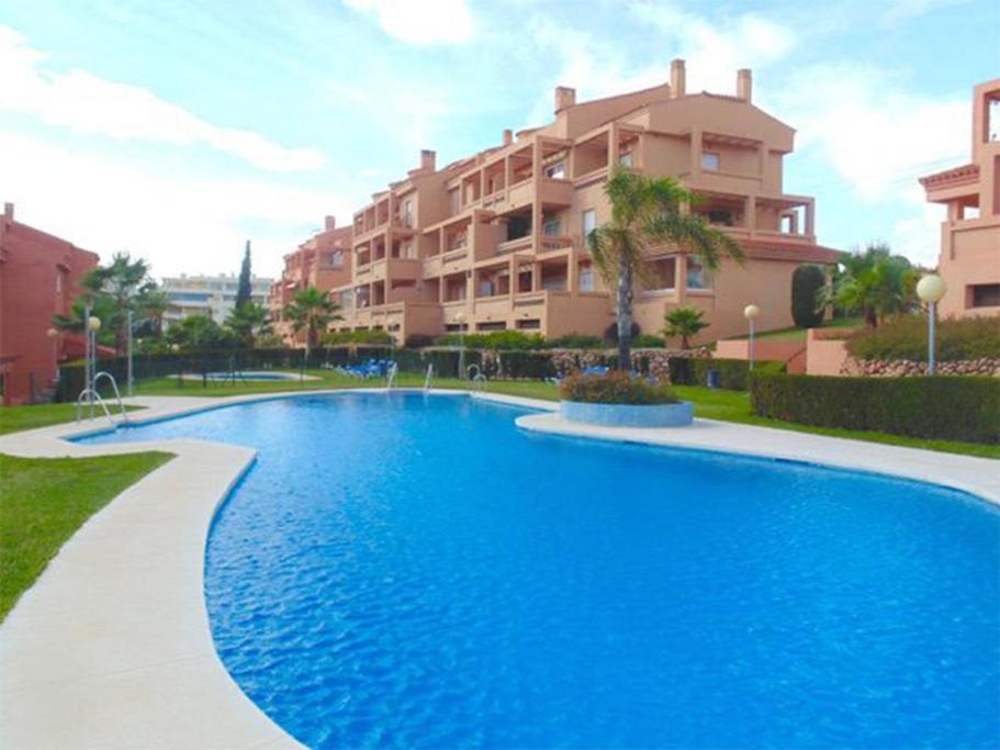 a large blue swimming pool in front of a building at Luxurious Apartment 2 Bedroom 2 Bathroom Near Beach in Málaga