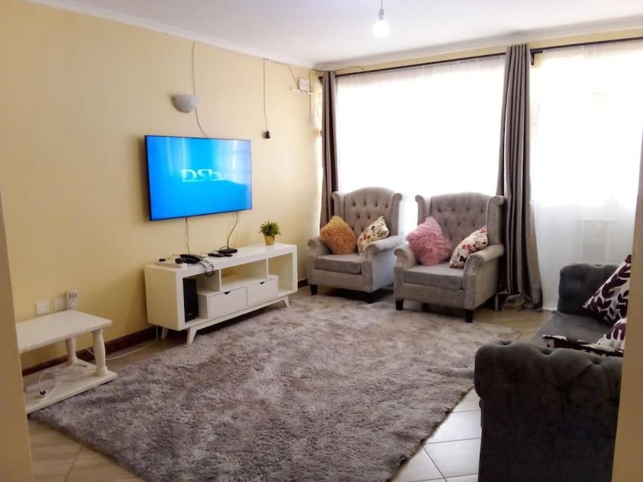 a living room with a flat screen tv on a wall at Greenvale's 2 Bedroom in Eldoret