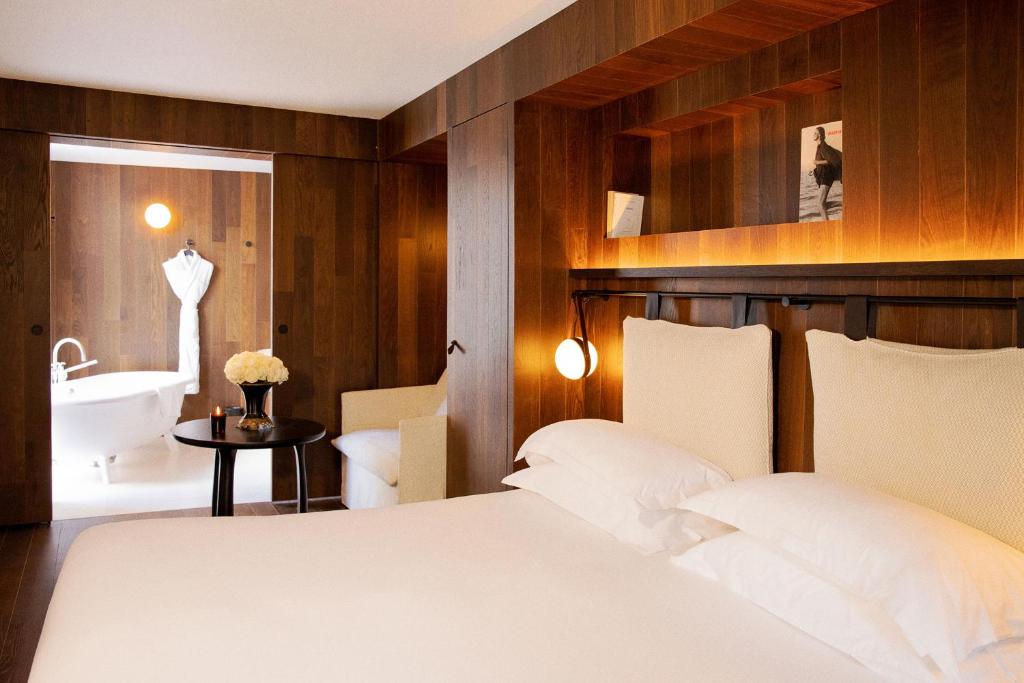 een slaapkamer met een bed en een badkamer met een wastafel bij Hôtel Bourg Tibourg in Parijs