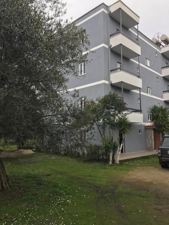 a gray building with trees in front of it at Vila 3 in Himare