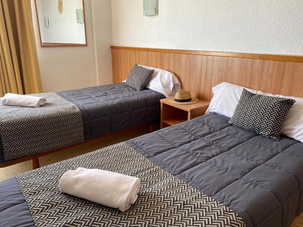 a hotel room with two beds and a hat on a table at AR Bolero park in Lloret de Mar