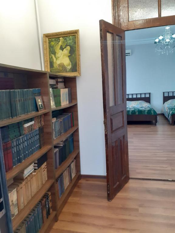 a room with a book shelf filled with books at U Asidy Guest House in Gudauta