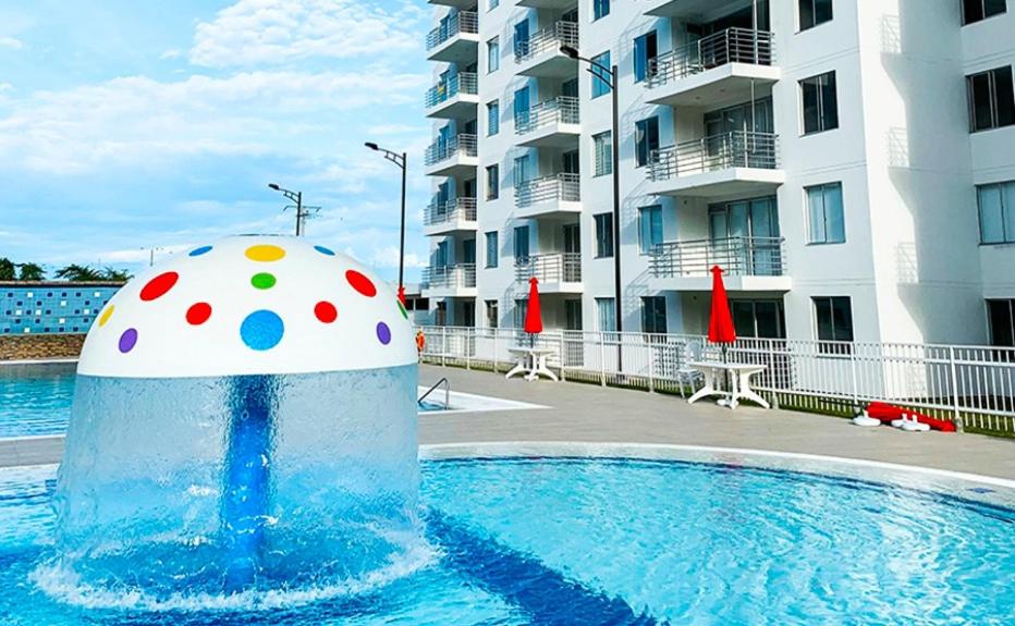 une piscine avec un ballon devant un bâtiment dans l'établissement Fresco y Cómodo Apartamento En Aqualina Orange Girardot, à Girardot