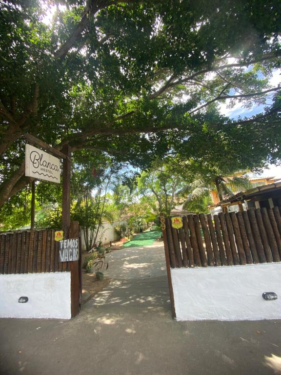 a gate at a park with a sign and a fence at pousada vida de Búzios recanto in Búzios
